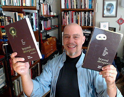 Tobias Beckwith holding his two Beyond Deception books which teach magicians creativity and performance techniques.